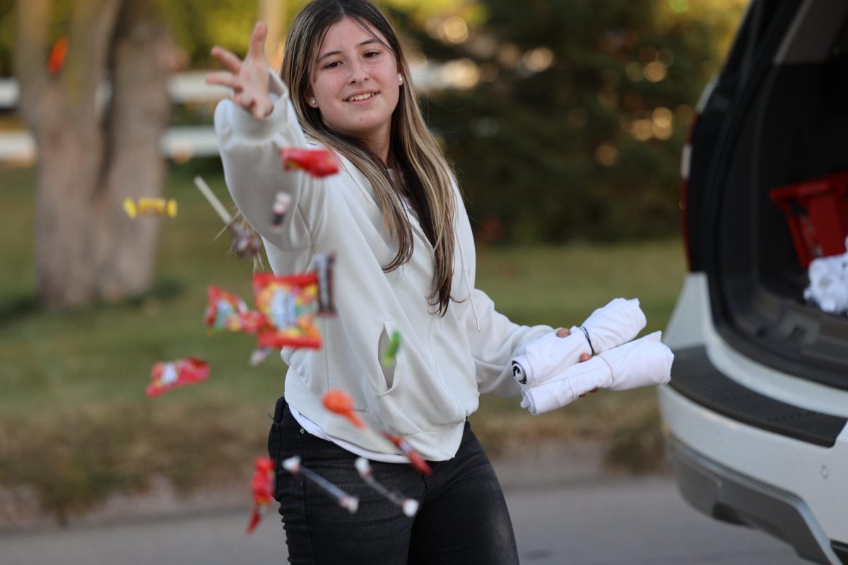 Senior Gabrielle Quirouette throws candy at the crowd while promoting the Stable during the MV Hoco Parade on Sept. 26. 