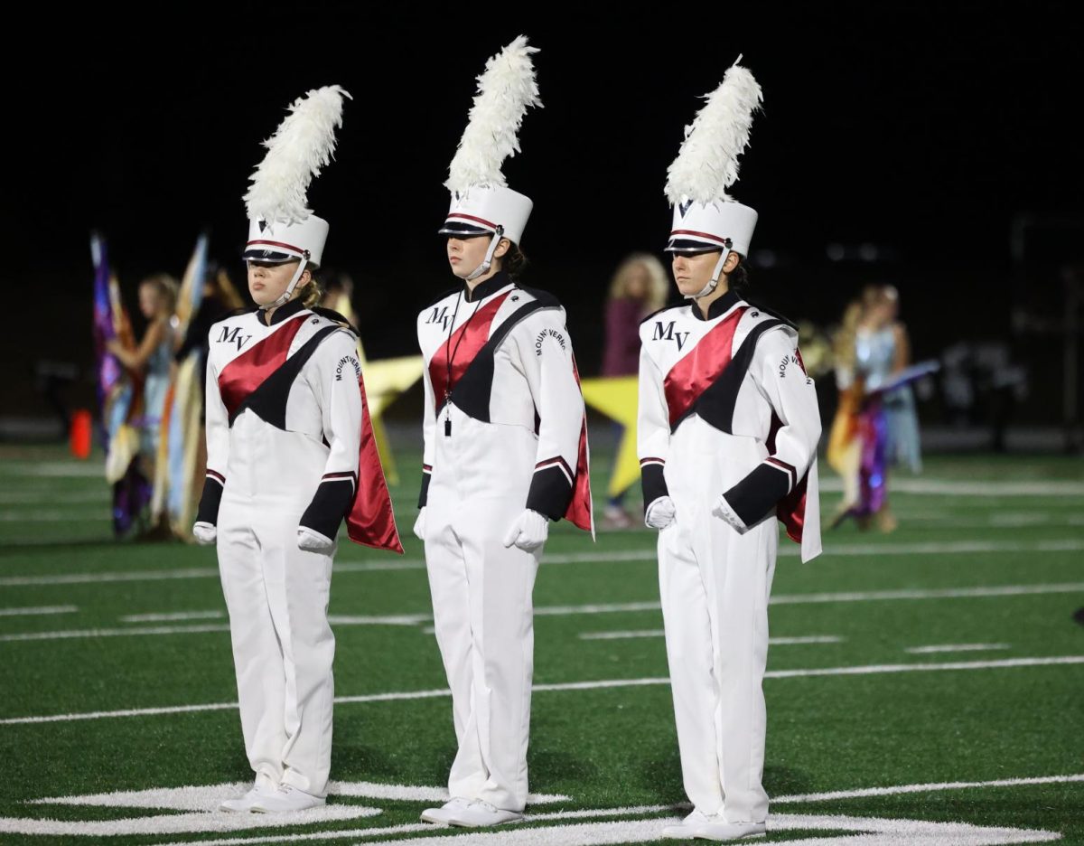 Drum majors junior Korah Jo Robinson, senior Clare Nydegger, and sophomore Anna Stephens wait to salute before their halftime show on Sept. 6.