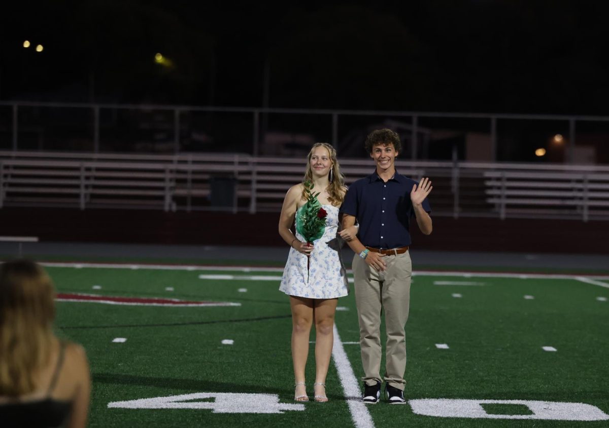 Homecoming Court nominees Natalie Thuerauf and Seamus O'Connor smile at the audience while waiting for the coronation to commence Sept. 26.