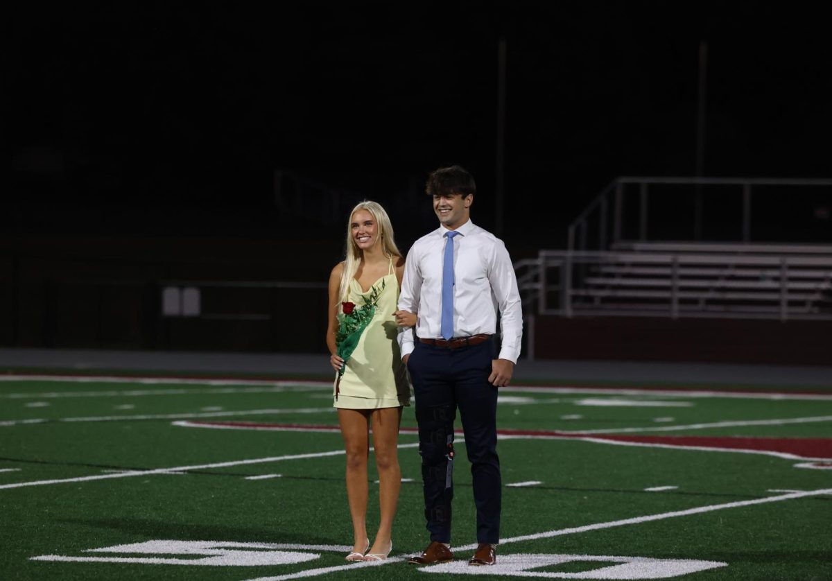 Court nominees Ethan Wood and Paige Schurbon stand together after walking onto the field Sept. 26.