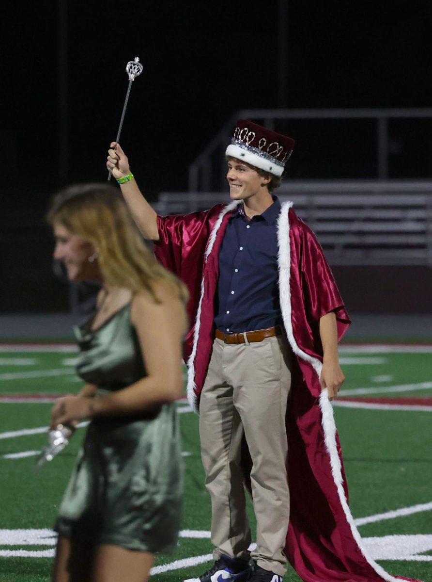 Homecoming King Seamus O'Connor victoriously raises the scepter after being crowned king Sept. 26.