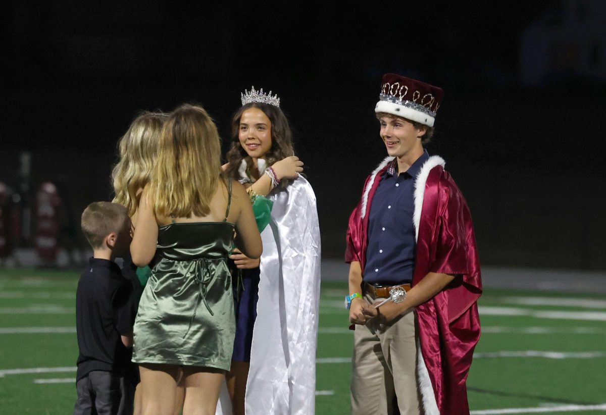 Homecoming Queen Betsy Louwagie and King Seamus O'Connor stand while the capes are being put on their shoulders Sept. 26.