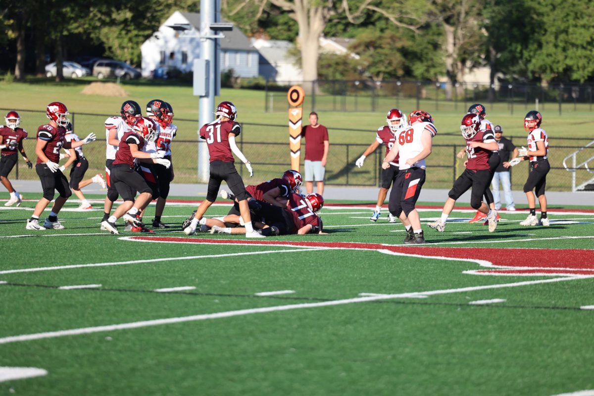 Freshmen Ryker Lee (77) and Cameron Poggenpohl (52) tackle a Union player during their first game on Sept. 6.