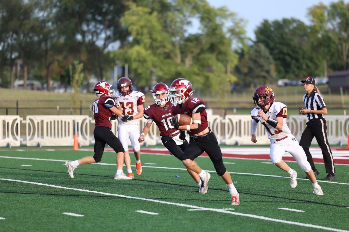 Freshman Holden Hlavacek (12) dodges the Mount Pleasant defense. The Freshman Mustangs lost to Mount Pleasant 32-20  Sept. 27.