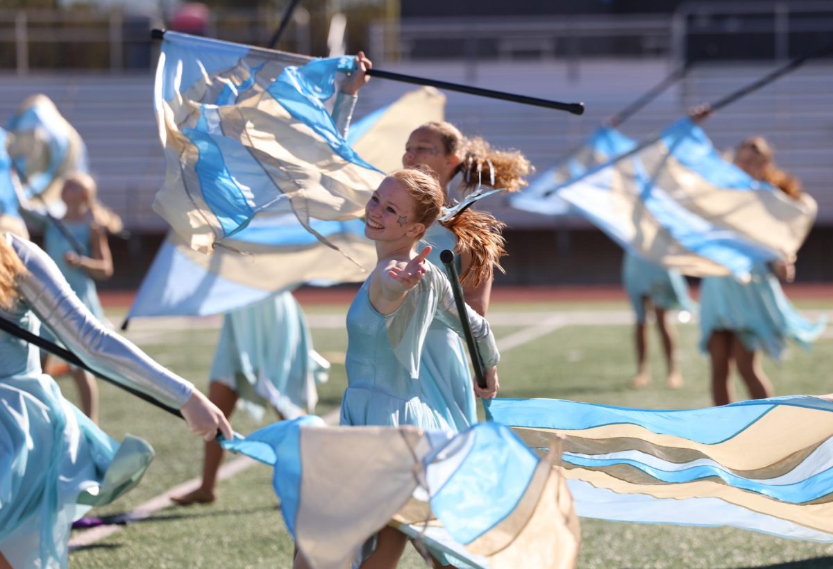 Junior Ingrid Morf runs through the color guard during the band's performance on Sept. 28.