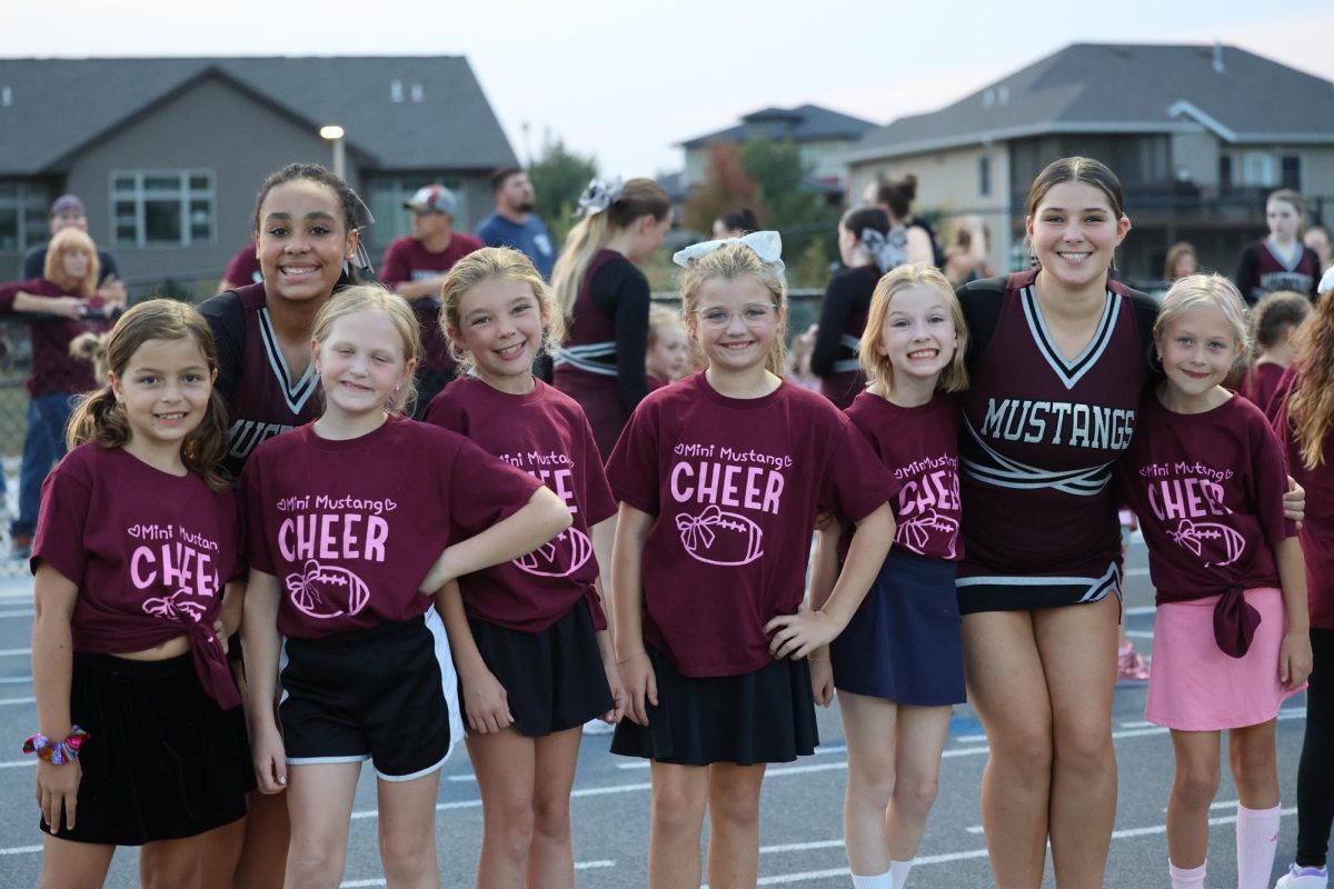 Sophomore Mia Panos and Junior Cait O'Connor smile with 3rd grade mini mustangs they teach on Friday the 11th