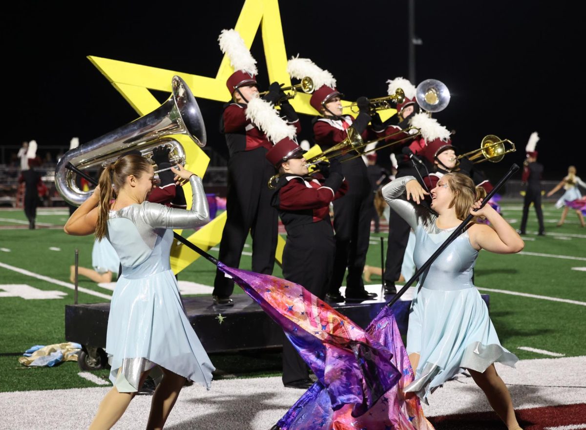 Senior Renee Vig and Junior Mae Krapfl complete their color guard duet as the brass ensemble plays on Oct. 11. 