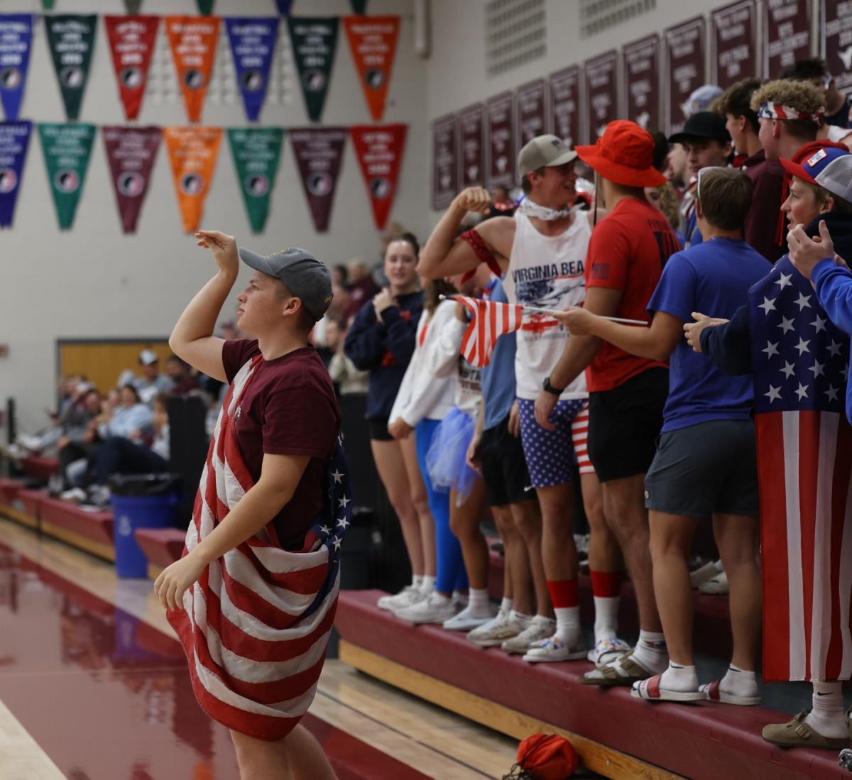 Senior Bennett Harp enthusiastically tosses the ball to the volleyball team while the student section cheers behind him Oct. 24. 