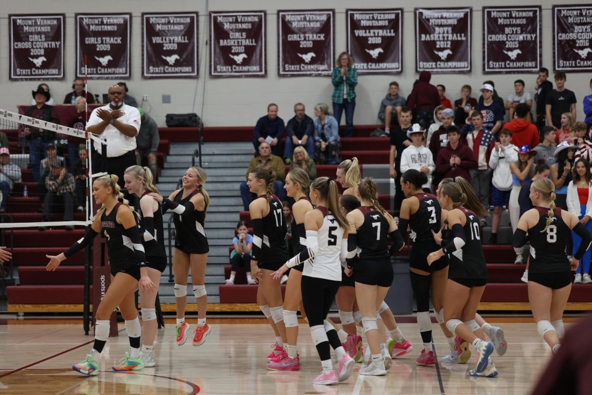 The Mount Vernon volleyball team runs to the net to shake hands with the opposing team after their win on Oct. 24. 