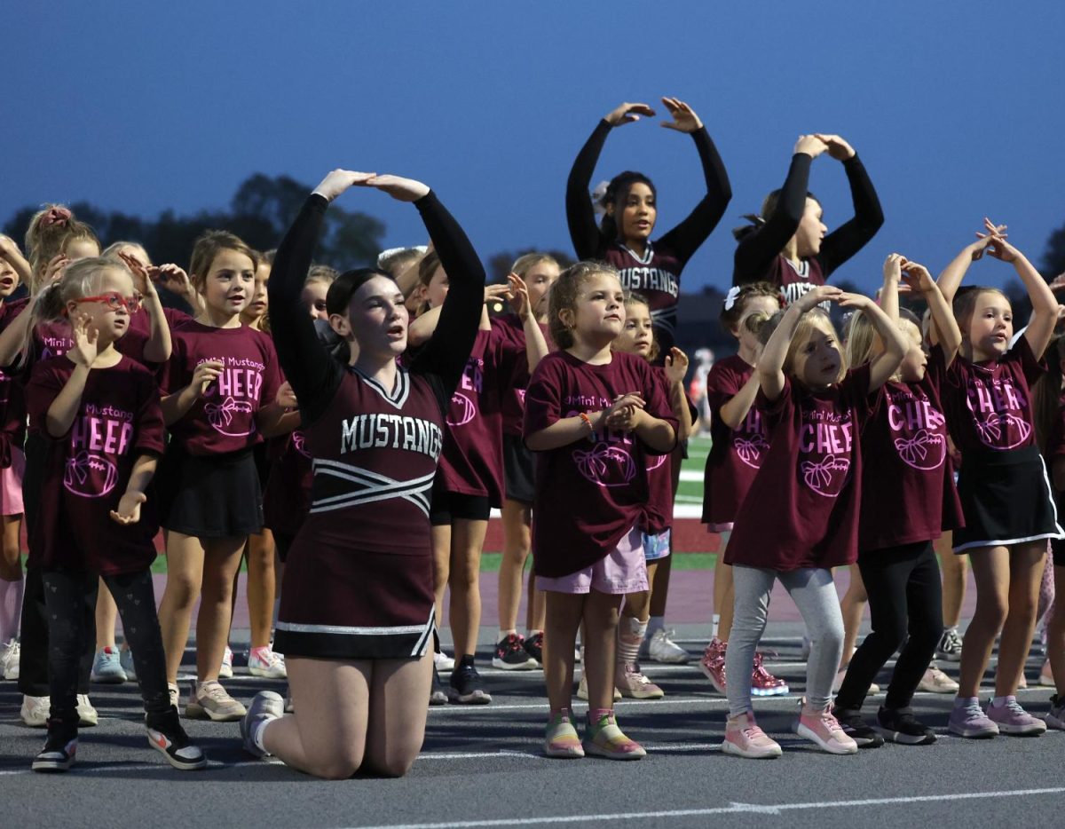 Cheerleader Broolyn Federson Cheers with 1st grade mini mustangs on Friday the 11th