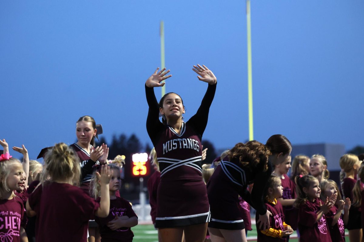 Sophomore Harmony Ireland Spirits to the crowd after cheer with Mini Mustangs on Friday the 11th