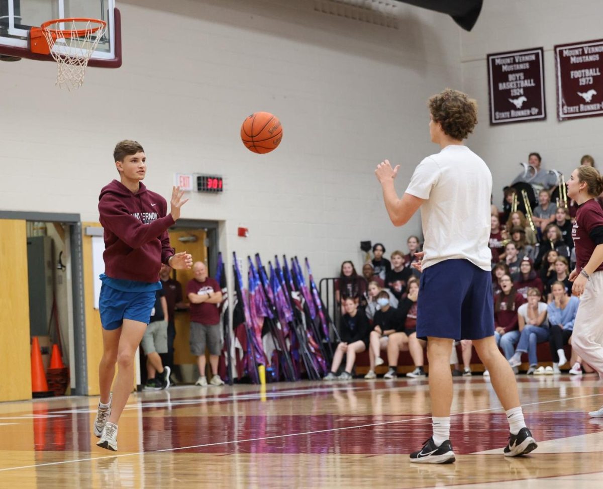 Senior Cayden Scheil passes the ball to the Hoco King senior Seamus O'Connor during the MV Pep Rally. 