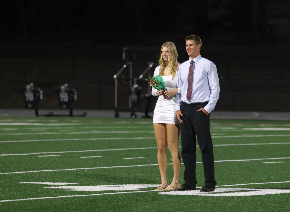 Court nominees Chloe Meester and Joe Briesmeister wait on the field before the King and Queen are announced Sept. 26.