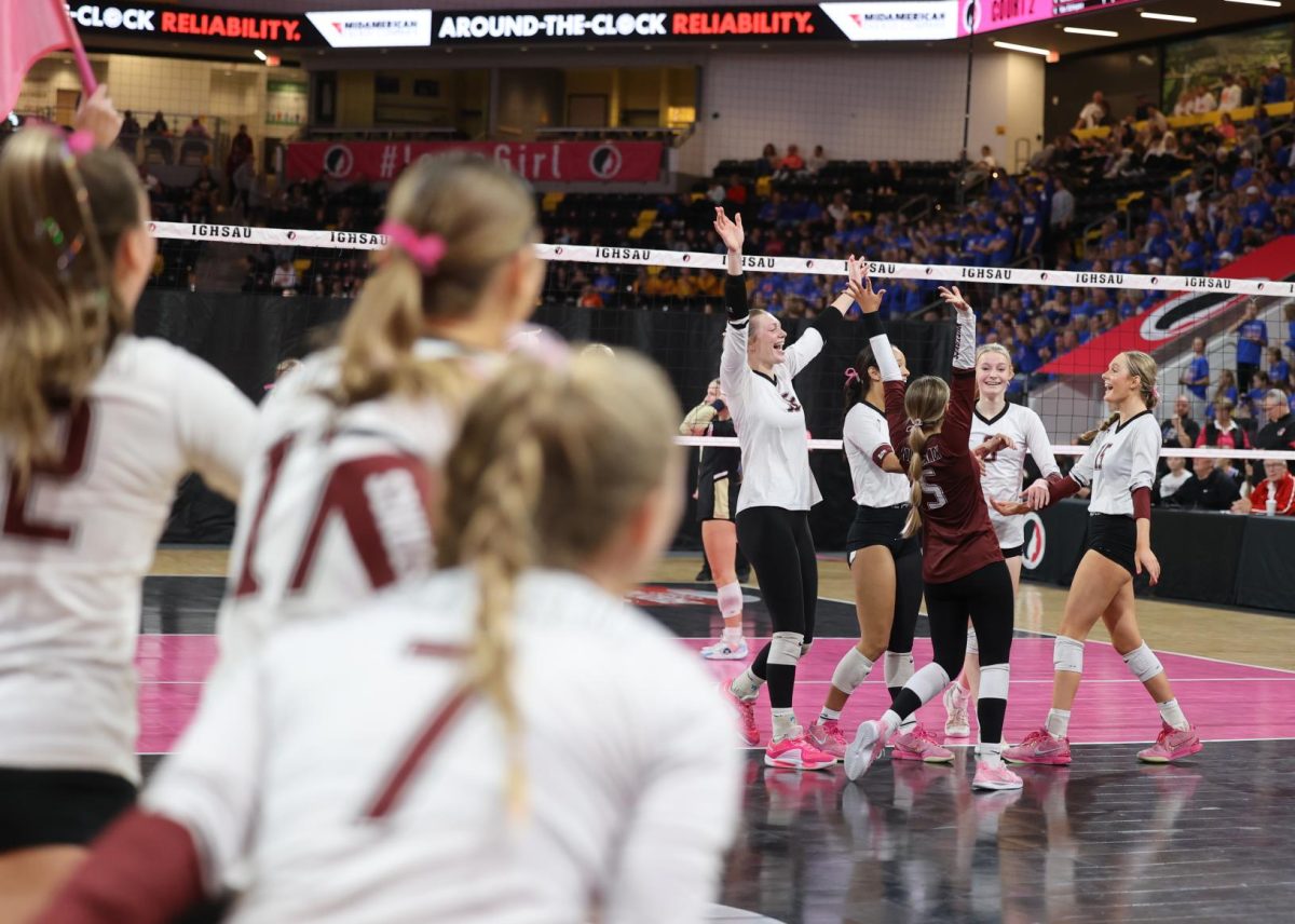 The Mount Vernon varsity volleyball team cheers after winning their quarterfinal game as the rest of the team rushes onto the court to celebrate with them.  Mount Vernon won the game against Mid-Prairie 3-0 on Nov. 5.