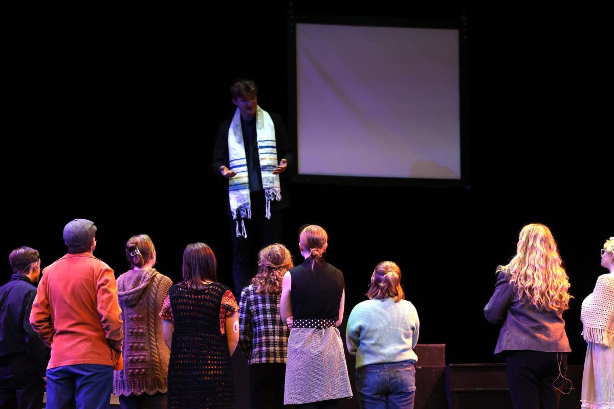 The cast of 26 Pebbles listen intently as Cyrus Johnson (Rabbi) talks to them.