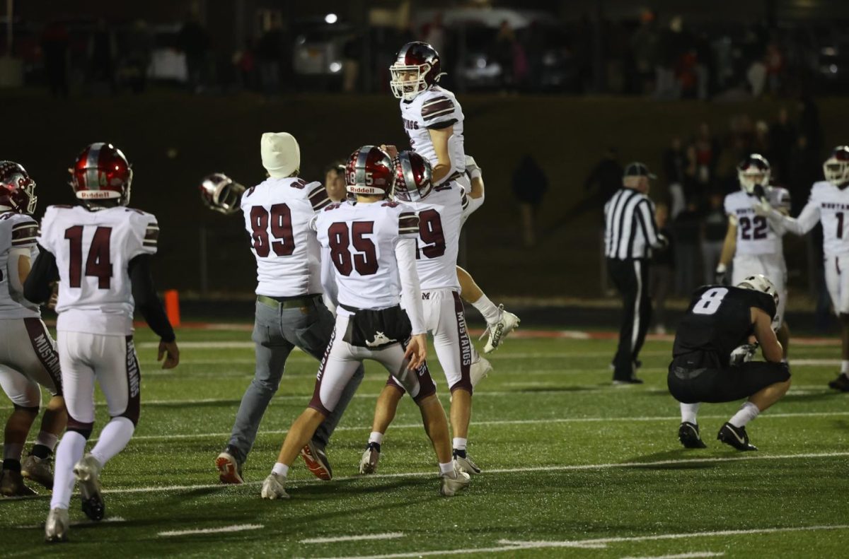 Cole Thurn (19) lifts up Kellen Haverback as they and their teammates celebrate their 31-28 win. 