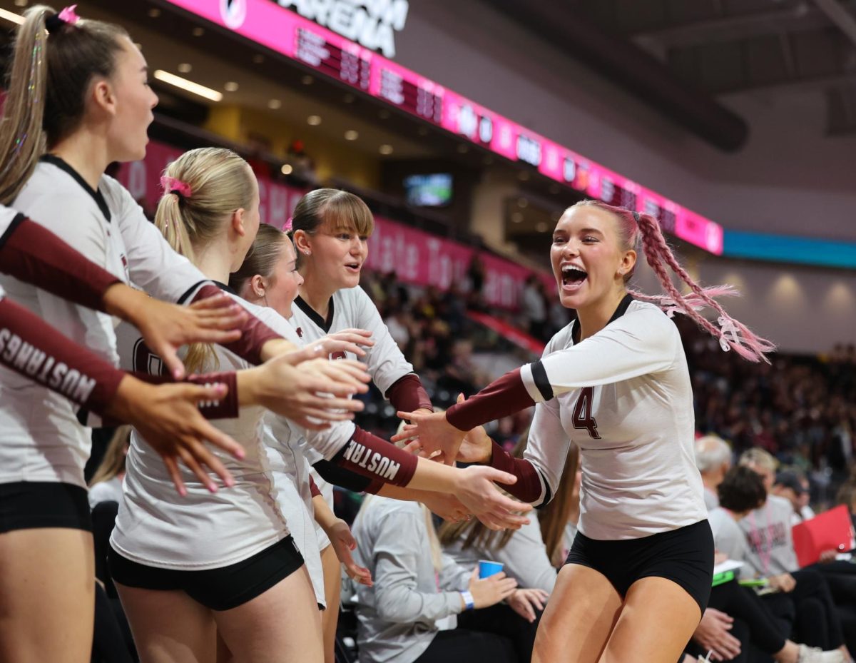 Senior Paige Schurbon (4) celebrates with her team as she leaves the court Nov. 5. 