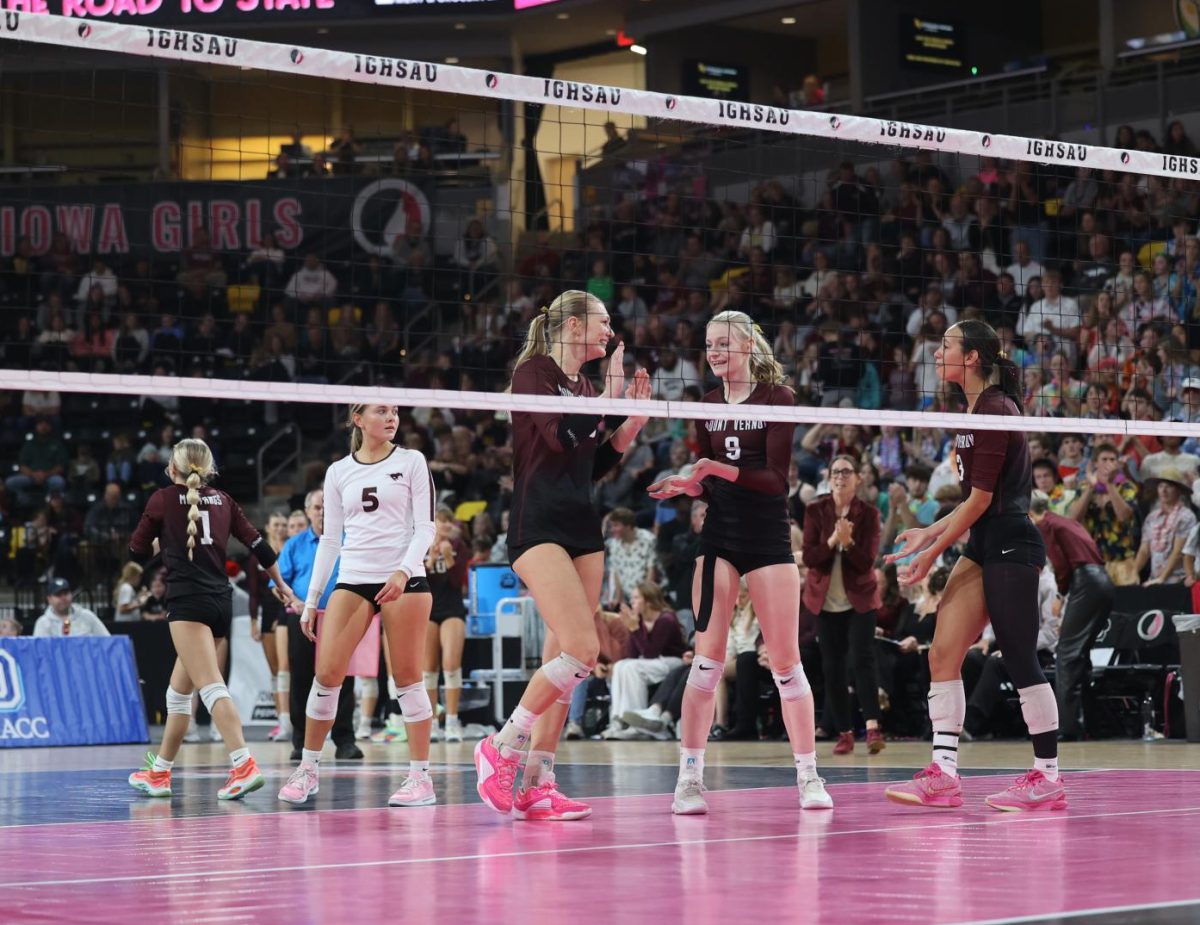 Seniors Chloe Meester (16) and Sydney Maue (9) high five after a kill against Western Christian Nov. 7.