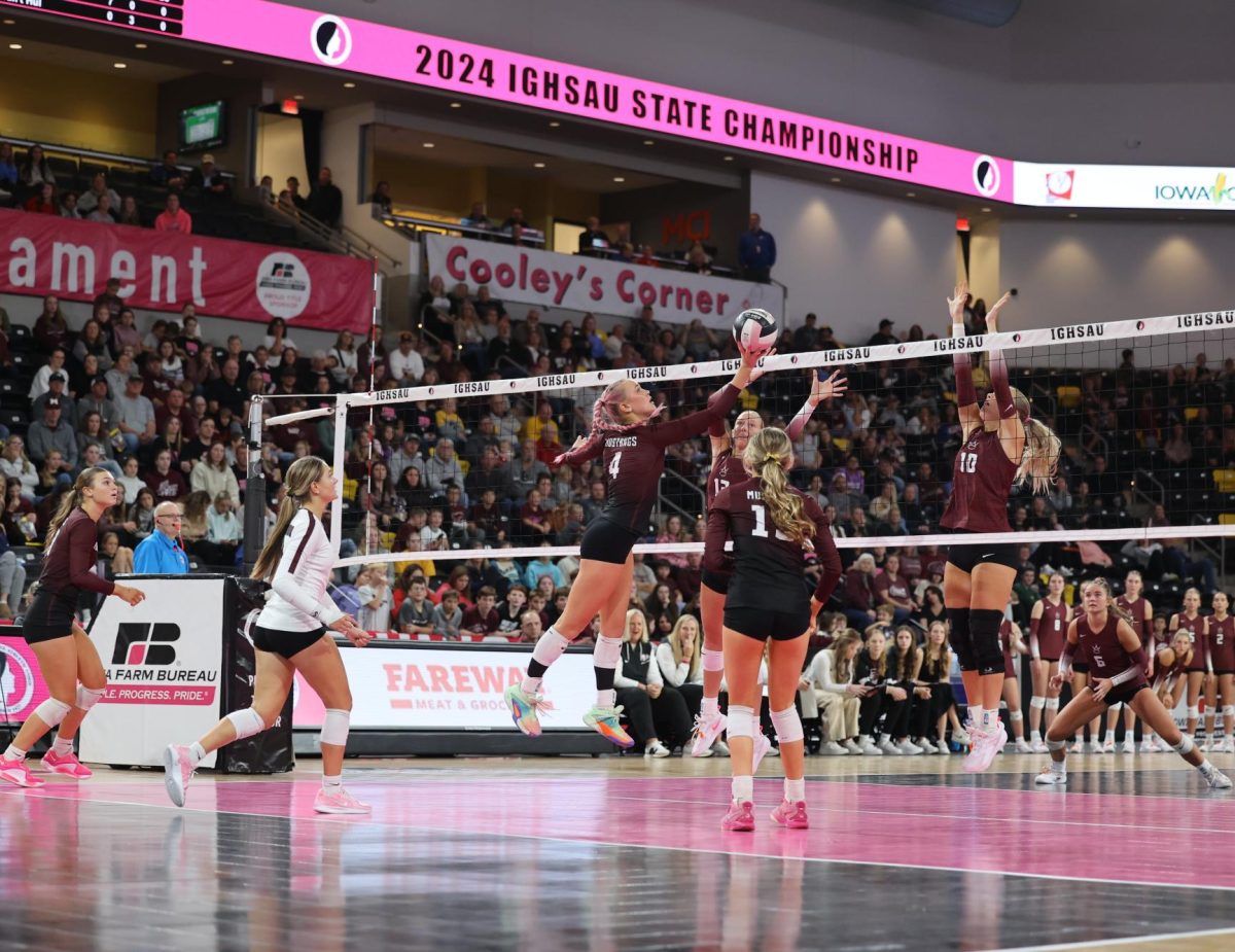 Senior Paige Schurbon (4) reaches to tap the volleyball over the net Nov. 7.