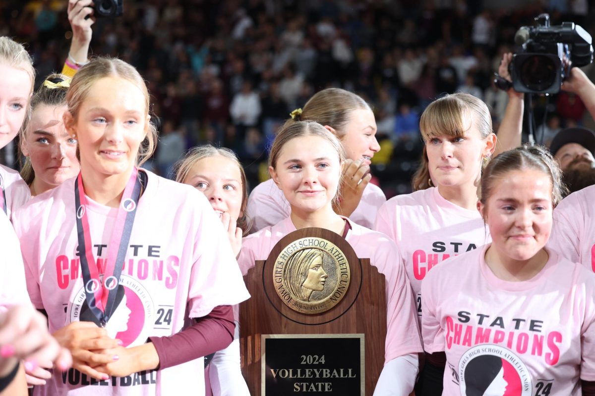 Senior Eryn Jackson holds the Volleyball State Champion trophy with her team surrounding her Nov. 7.