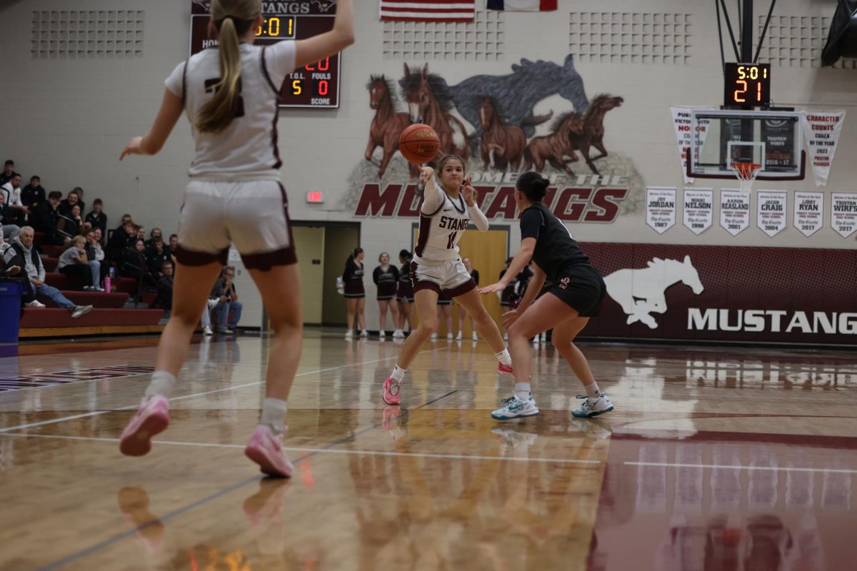 Junior Taylor Franck (11) reaches around the Williamsburg opponent to pass the basketball Dec. 13. 