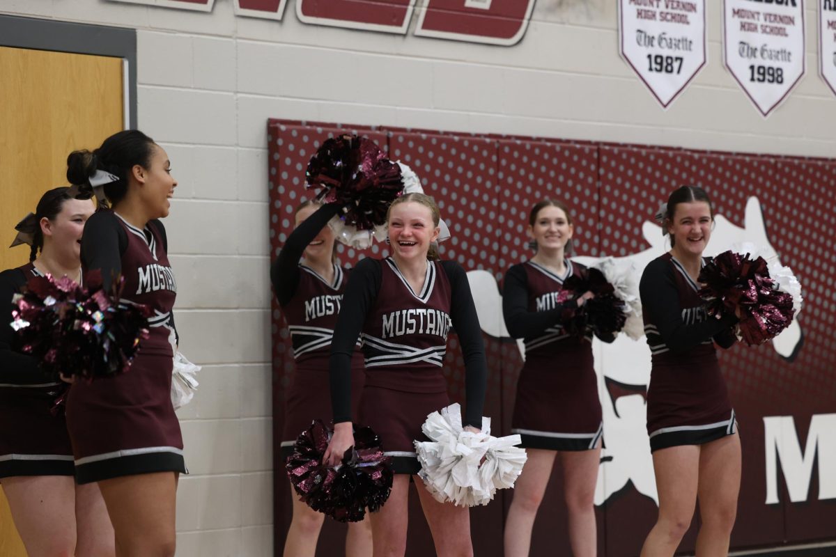 Sophomore Chloe Lynner and the rest of the cheer squad laugh while at the home basketball game on Dec. 13. 