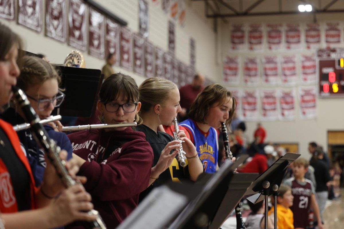 Senior Natatlie Thuerauf plays her flute with the rest the pep band at the double header basketball game on Dec. 13. 