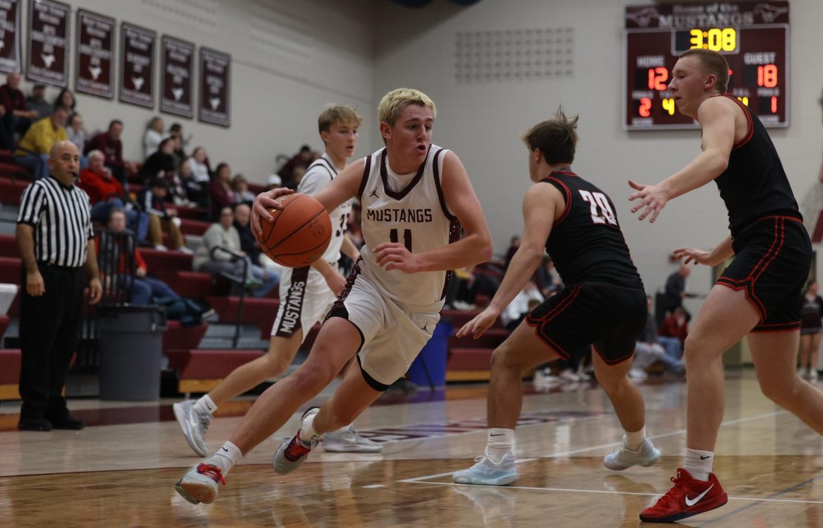 Junior Kellen Haverback (11) runs with the ball to make a layup. The Mustangs ended up winning against Williamsburg 52-40 on Dec. 13. 