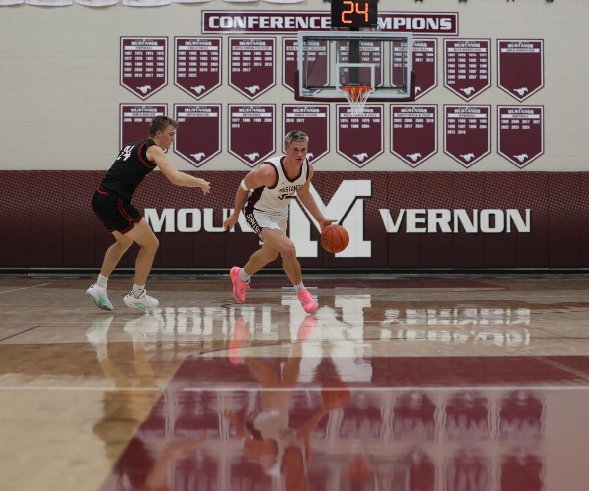 Senior Josef Briesemeister (32) dribbles the basketball up the court Dec. 13.