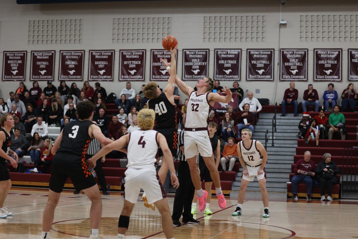 Senior Josef Briesemeister (32) reaches for the basketball during tip-off. The Mustangs ended up winning the game against Solon 54-40 Dec. 17. 