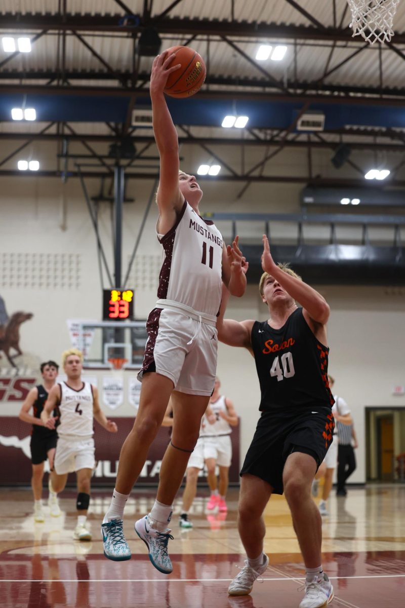 Junior Kellen Haverback (11) jumps to put the basketball into the hoop Dec. 17. 