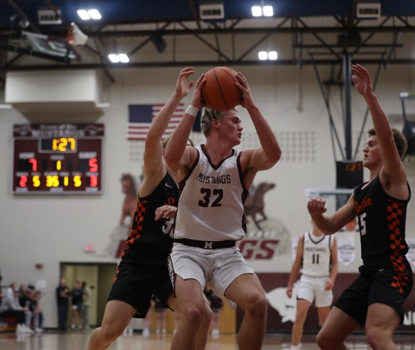 Senior Josef Briesemeister (32) looks to shoot the ball while cornered by two defenders Dec. 17