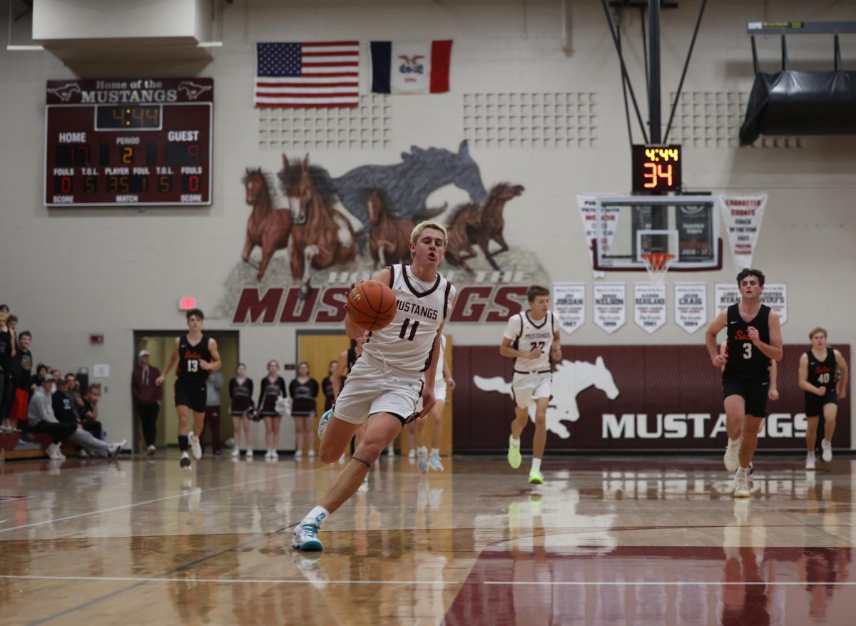 Junior Kellen Haverback (11) takes the basketball down the court after stealing it from his opponent Dec. 17.