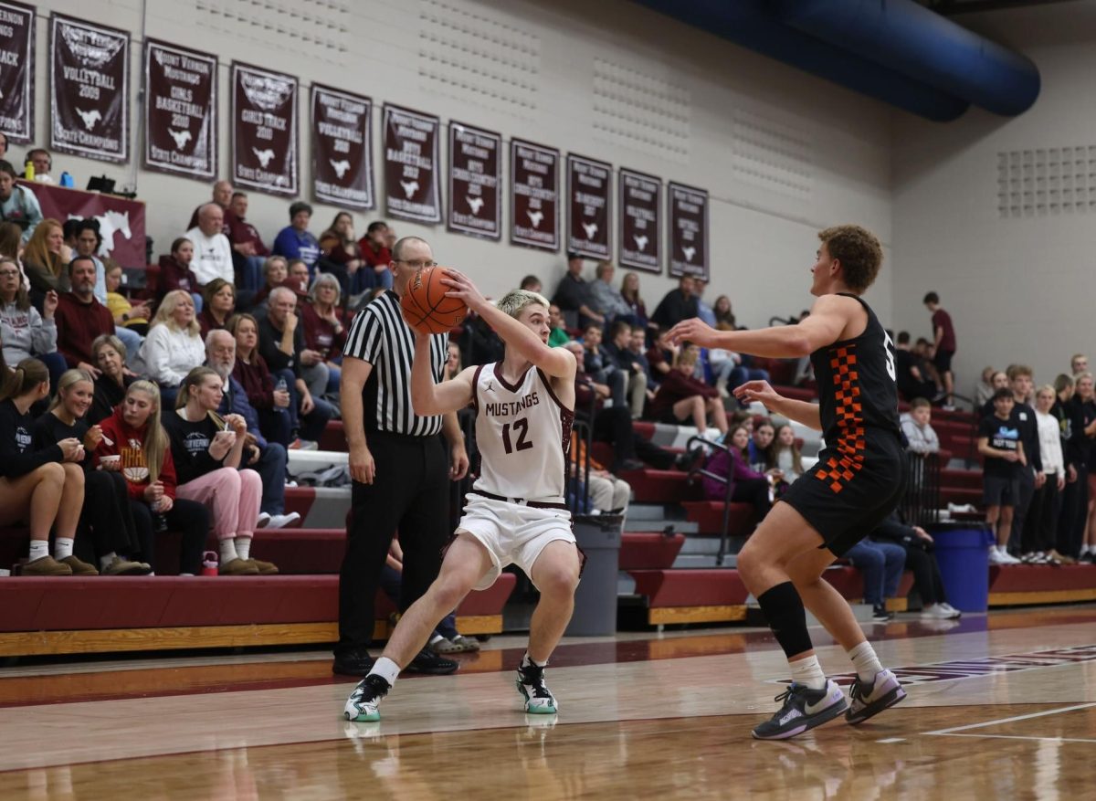 Senior AJ McDermott (12) keeps the ball away from his Solon opponent Dec. 17. 