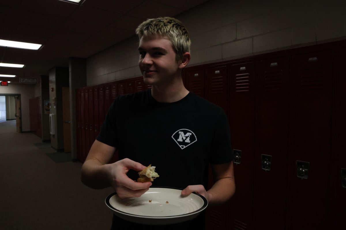 Senior AJ Mcdermott eats a hamburger in his farm to table J-Term class.