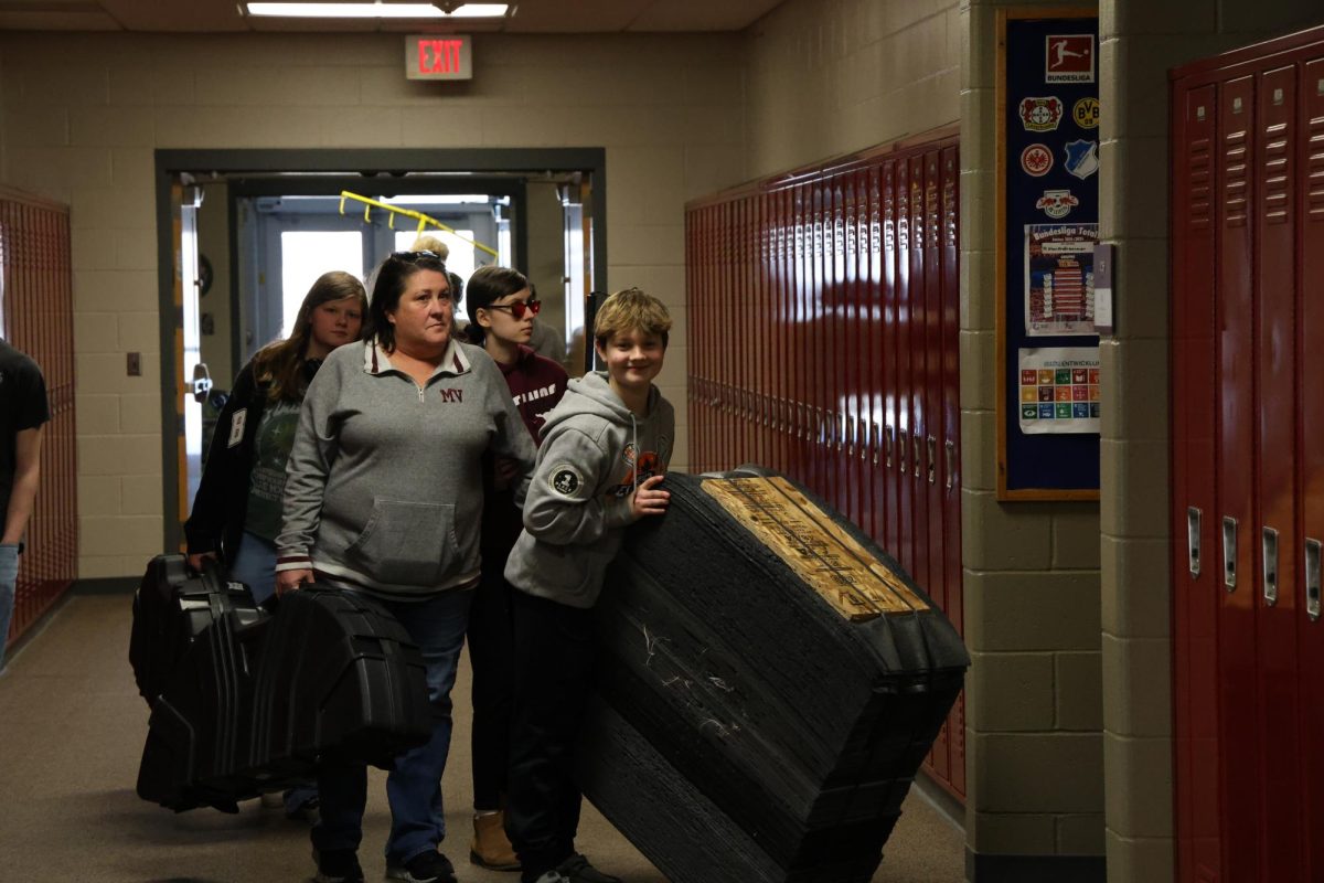 Freshman Calvin Crawford helps put away target after participating in archery during the Freshman Experience J-Term.