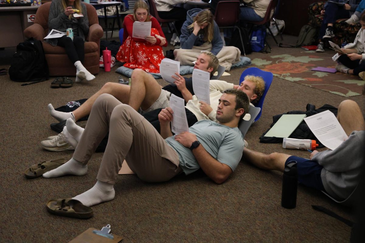 Seniors Ethan Wood, Cole Thurn, and Kael Riniker read a paper during their mindfulness J-term.  