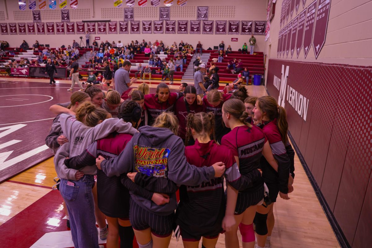 The Mount Vernon Girls Wrestling team ranked #5 in Class 1A gathers for a moment before their first dual against Grinnell, Jan. 9. 