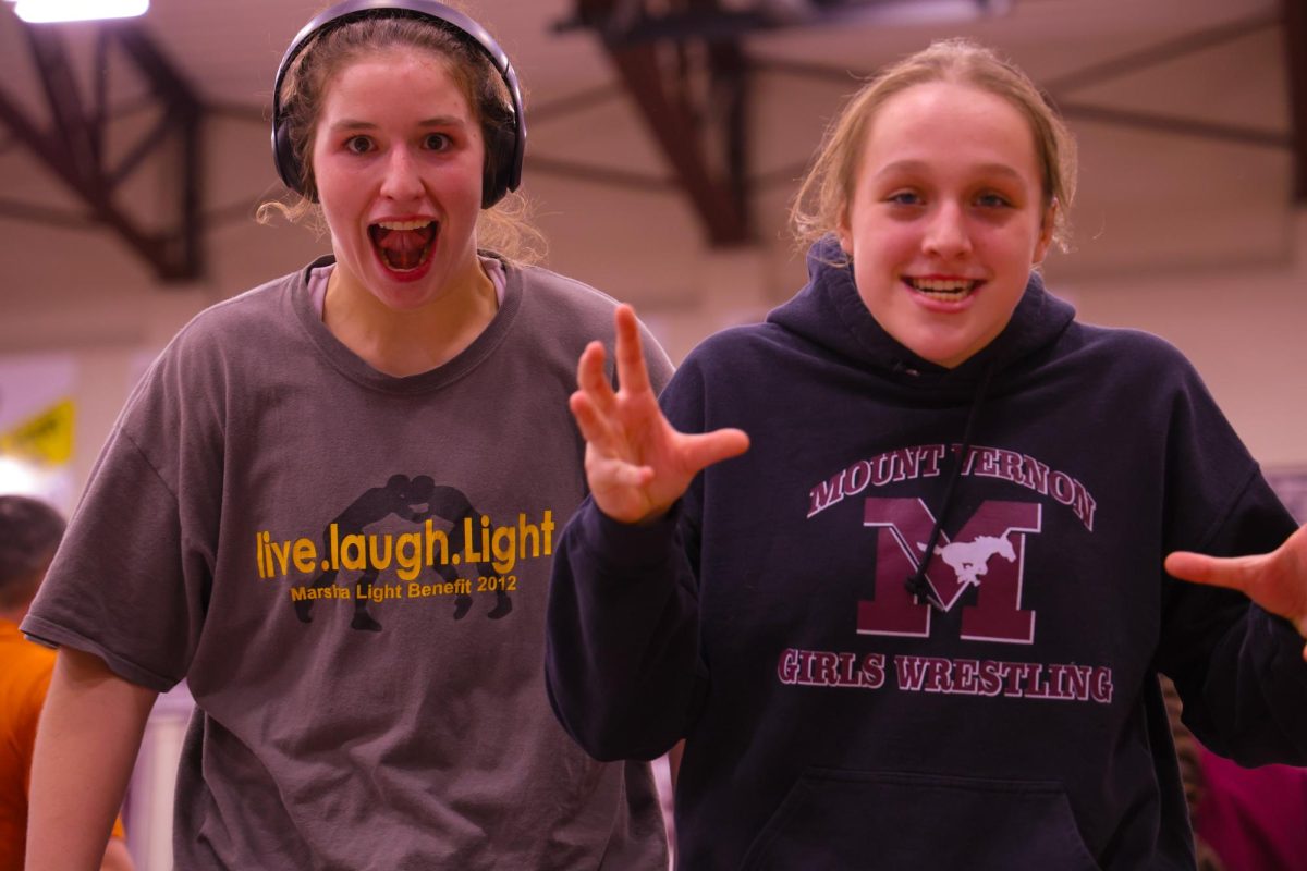 Senior Libby Dix and junior Gracie Pinckney pose for a picture after their teams dual win against Grinnell, Jan. 9. 