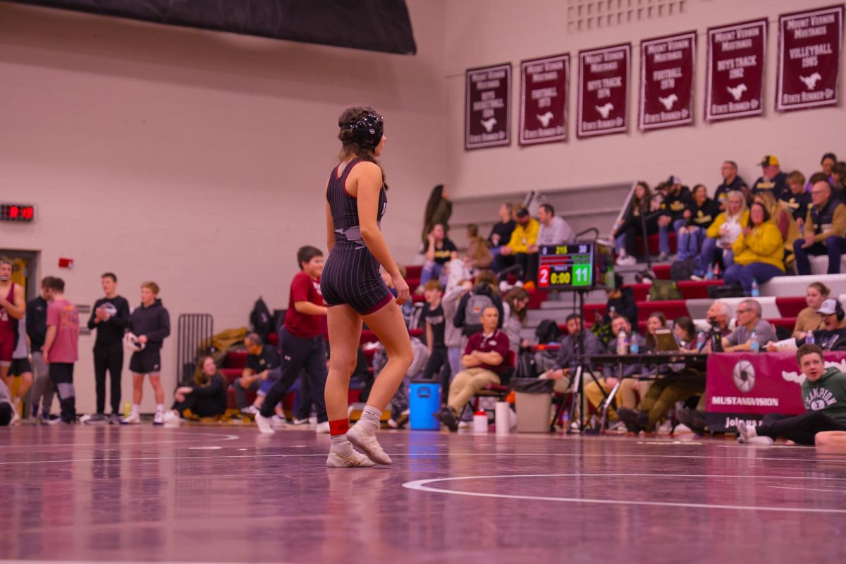 Junior Carly Elliott paces around the mat while referees are having technical difficulties with the scoreboard, Jan. 9. 