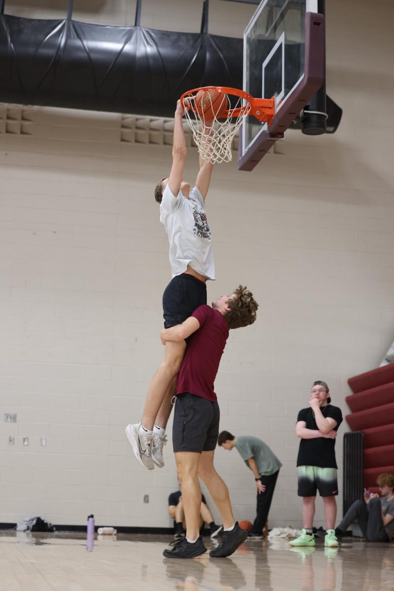 Sophomore Xander Riniker assists Junior Xander Wegner to dunk the basketball during their Exercise Science J-Term.