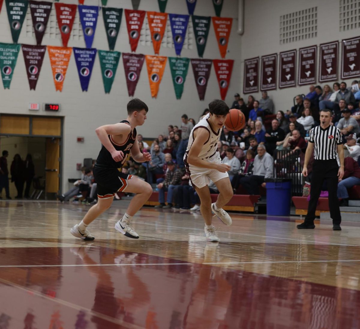 Junior Charlie Weldon (24) takes the basketball down the court while his opponent follows Jan. 28.