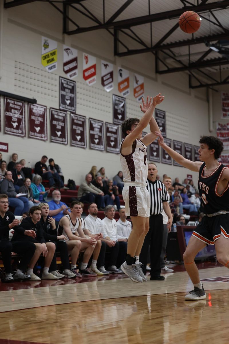 Junior Lewis Krob (0) jumps to shoot the basketball while his teammates stare in anticipation Jan. 28. 