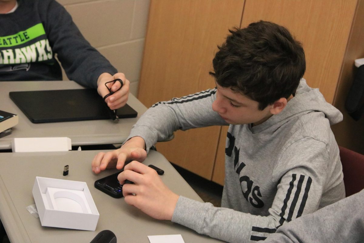 Sophomore Cooper Krob connects his microphone to his phone in the Digital Media J-term course.