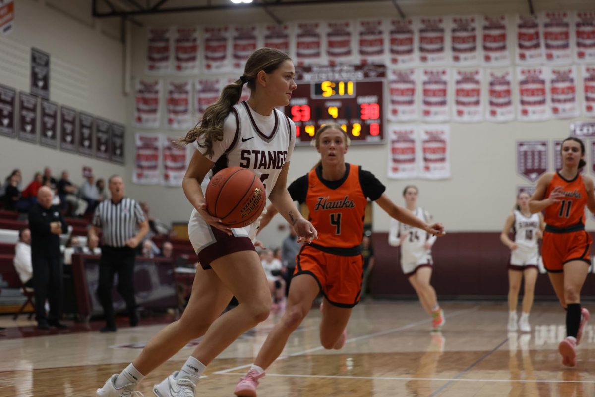 Senior Eryn Jackson (5) focuses as she runs into the paint with the basketball Jan. 28.