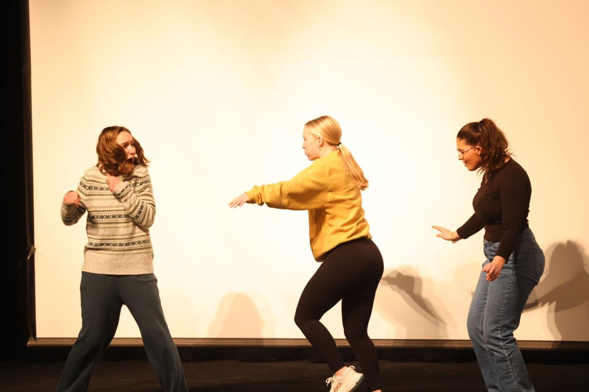 Senior Bella Hasley reacts scared as senior Natalie and junior Cait O'Connor act as dragons during their improv skit Feb.15. 