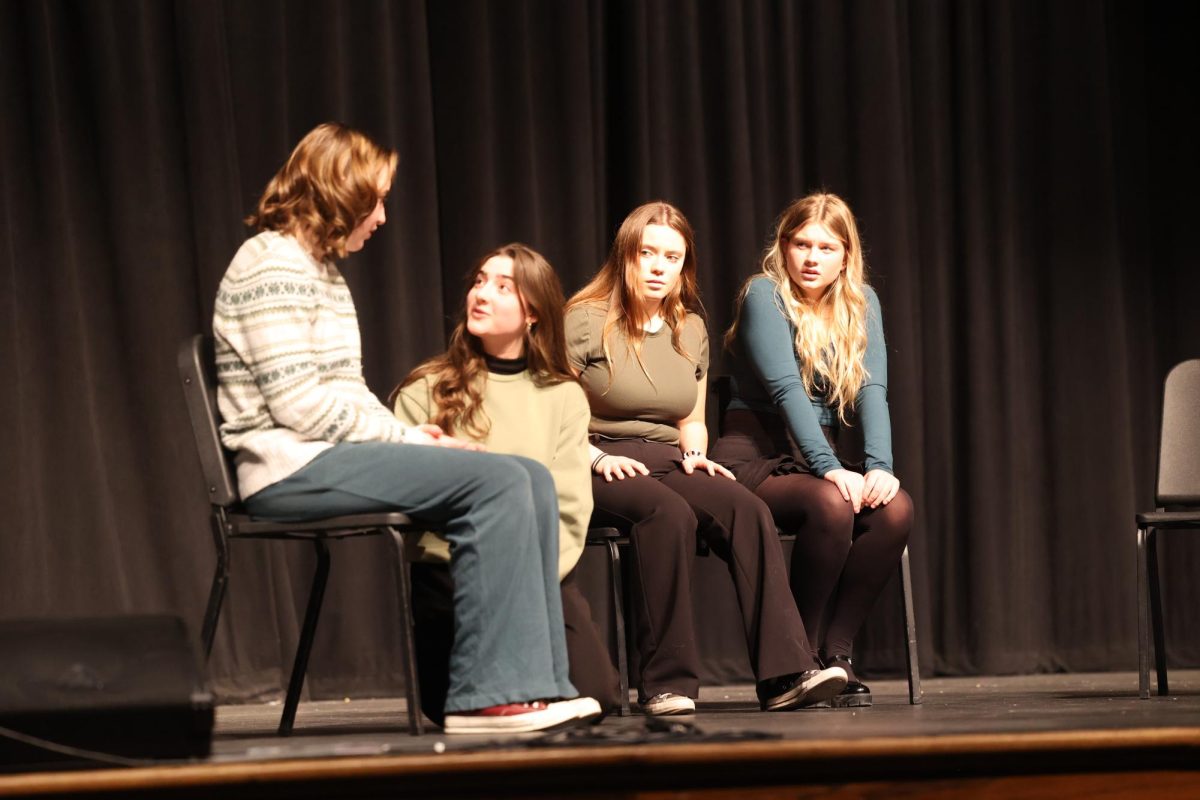 Junior Emara Perreault talks to Senior Bella Hasley while her daughters look at them during their ensemble acting "Sisters" Feb.15. 