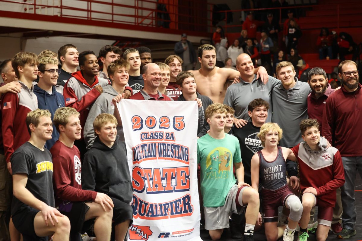 The Mount Vernon Wrestling Team poses Feb. 4 with their banner as a 2025 State Qualifier at Davenport Assumption. 