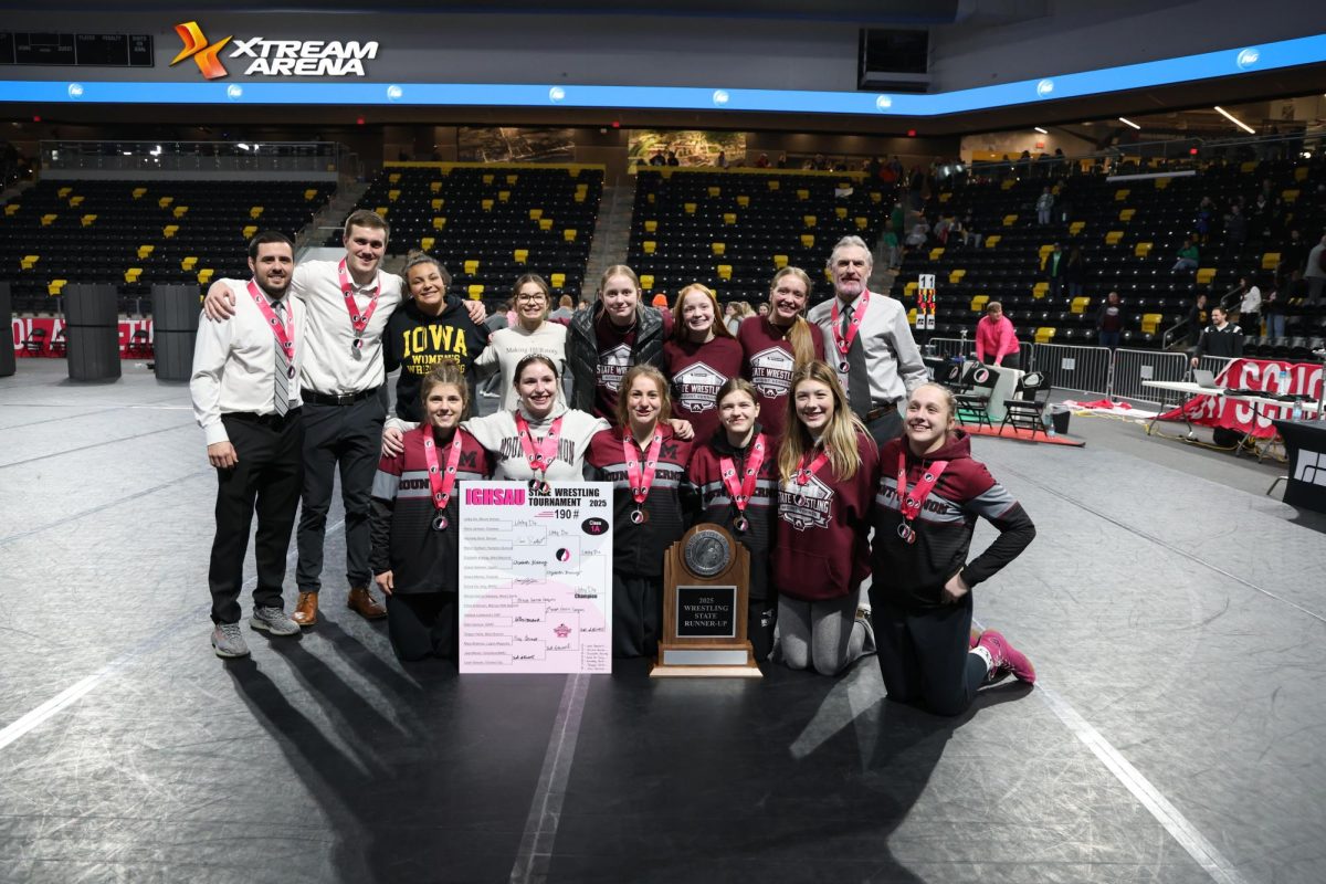 The state qualifying wrestlers, coaches, and managers pose with the State Runner Up trophy.