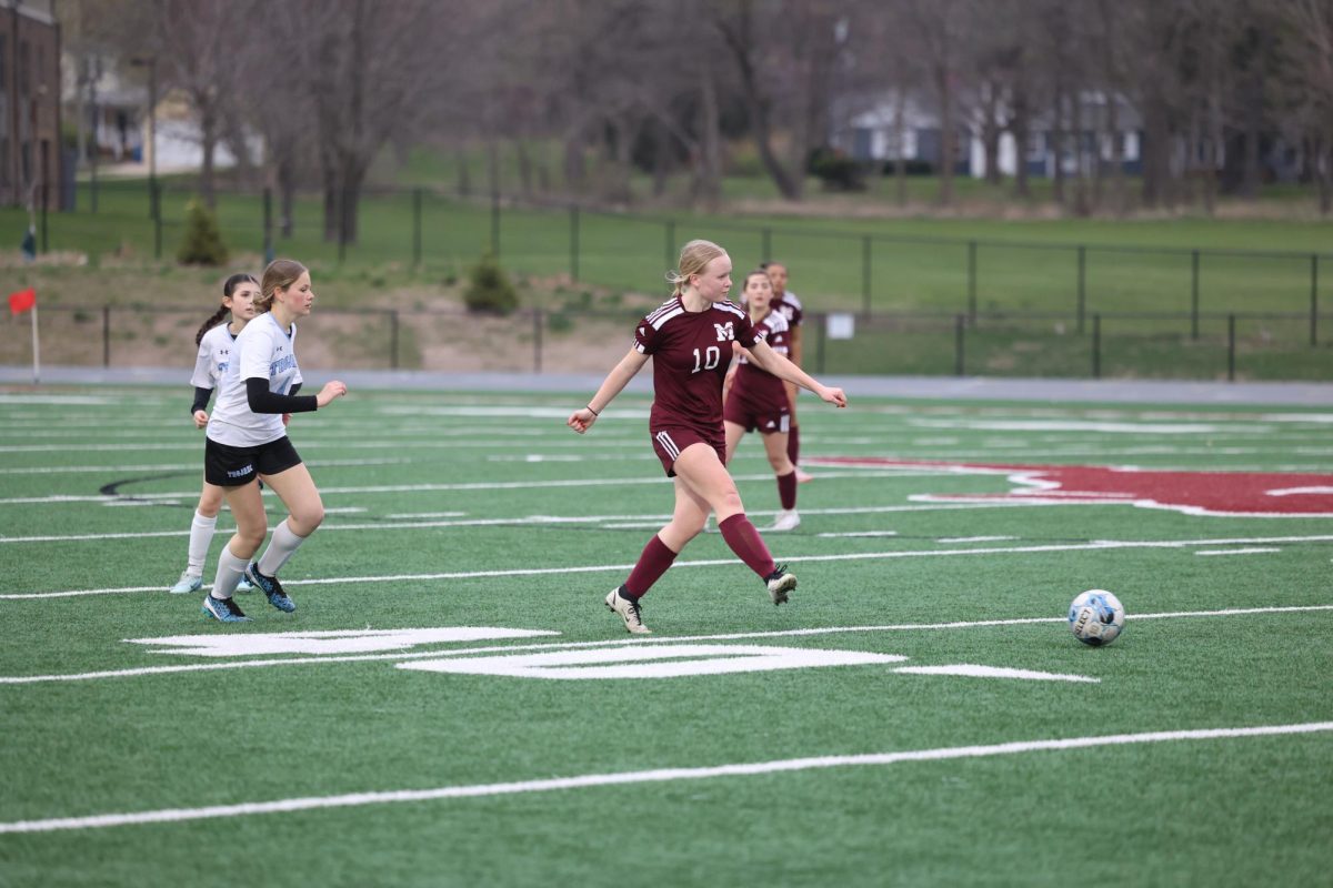 Junior Emma Hoffman (10) passes the ball to her teammate just as a South Tama defender comes up to steal it April 17.
